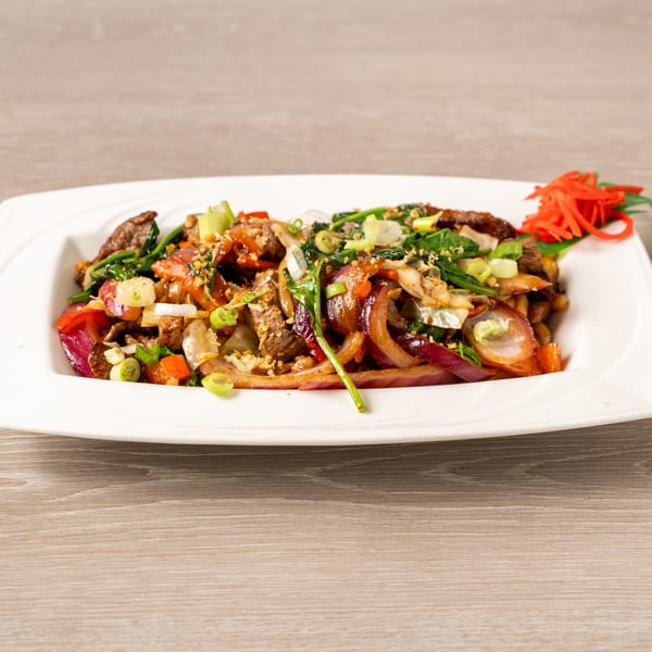 Japanese stir-fried beef with red onions, green onions, and spinach, garnished with pickled ginger.