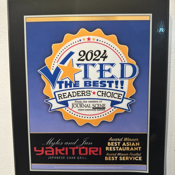 A framed award certificate for Myles and Jun Yakitori, voted "Best Asian Restaurant" and "Best Service" in 2024.