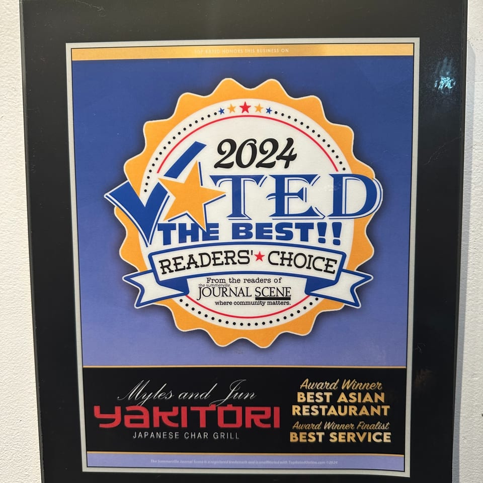 A framed award certificate for Myles and Jun Yakitori, voted "Best Asian Restaurant" and "Best Service" in 2024.