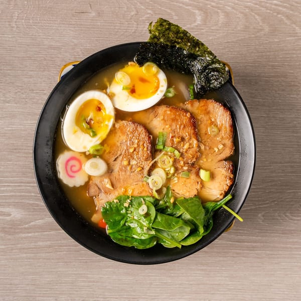 Overhead view of Myles and Jun Yakitori Japanese Char Grill ramen with pork, egg, spinach, and nori.
